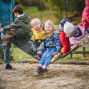 Kinder im Garten auf Schaukel